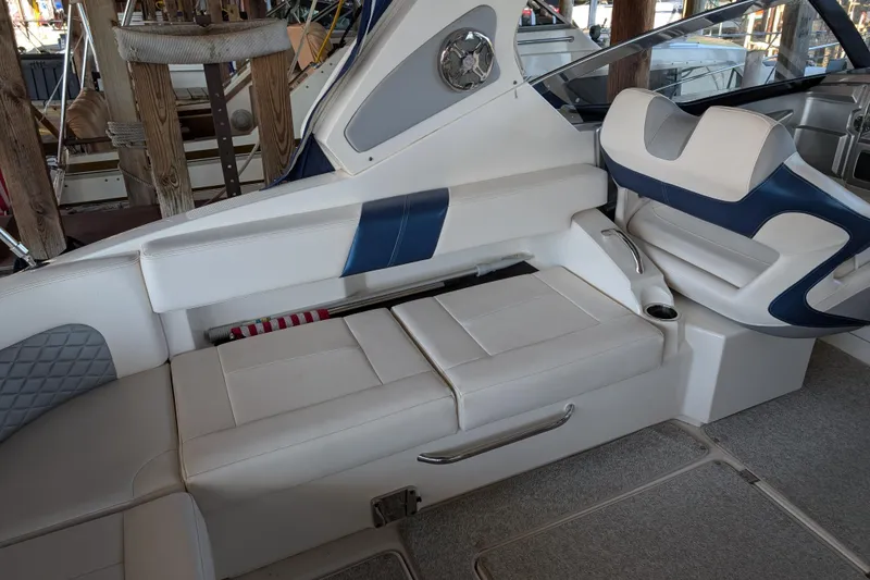 Slide: The Image of Interior seating of 2012 Chaparral 327 SSX boat, featuring white and blue upholstery. - 24
