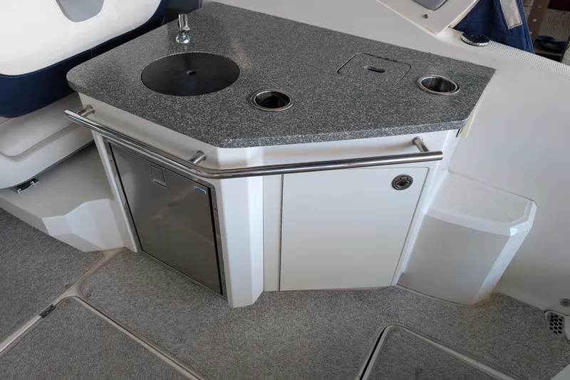 Slide: The Image of 2012 Chaparral 327 SSX boat interior with kitchenette and stainless steel fixtures. - 26