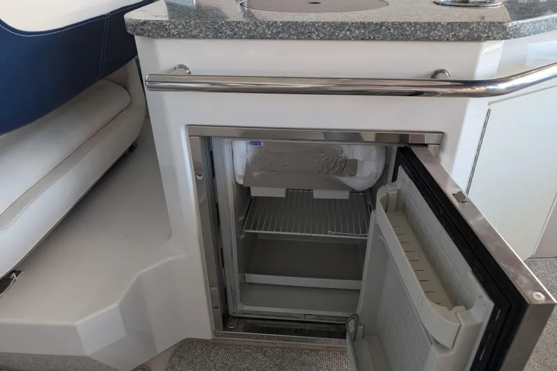 Slide: The Image of Open mini fridge on 2012 Chaparral 327 SSX boat, featuring a sleek countertop. - 27