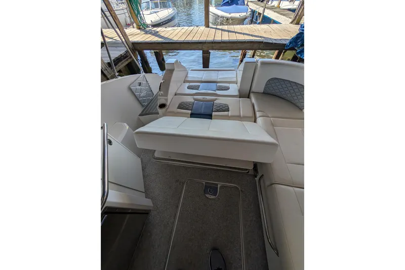 Slide: The Image of 2012 Chaparral 327 SSX boat interior with beige seating and dock view. - 30