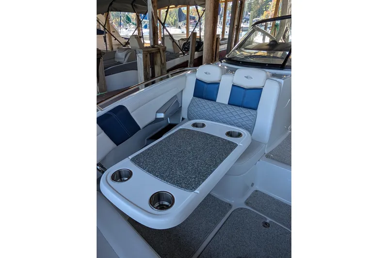 Slide: The Image of 2012 Chaparral 327 SSX boat interior with seating and table, featuring cup holders. - 9