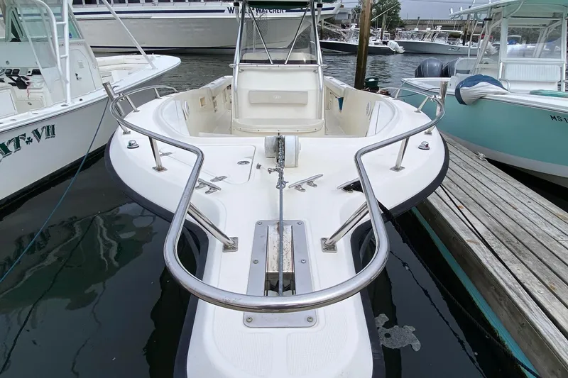 Slide: The Image of 2005 Pursuit 2870 Center Console boat docked at marina, featuring spacious deck and railings. - 2