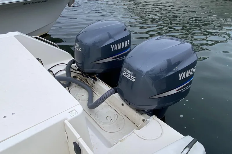 Slide: The Image of Twin Yamaha 225 engines on a 2005 Pursuit 2870 Center Console boat, docked on water. - 3