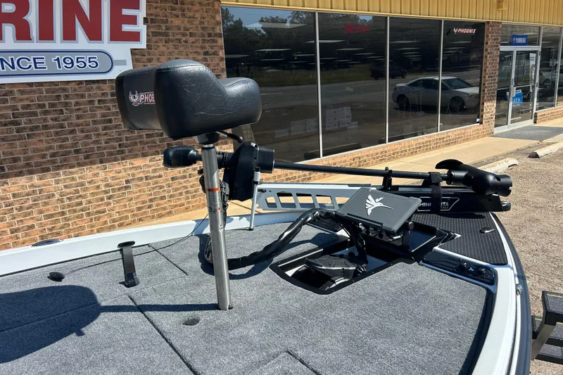 Slide: The Image of 2026 Phoenix 721 ZXL boat with trolling motor and seat, outside a marine store. - 3
