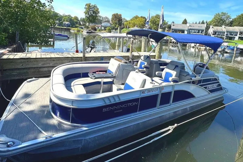 Slide: The Image of 2022 Bennington 23 LTFB pontoon boat docked on a sunny day. - 1