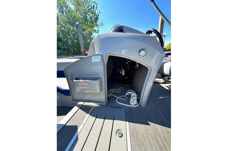 Slide: The Image of 2022 Bennington 23 LTFB boat interior with open storage compartment and ropes. - 11