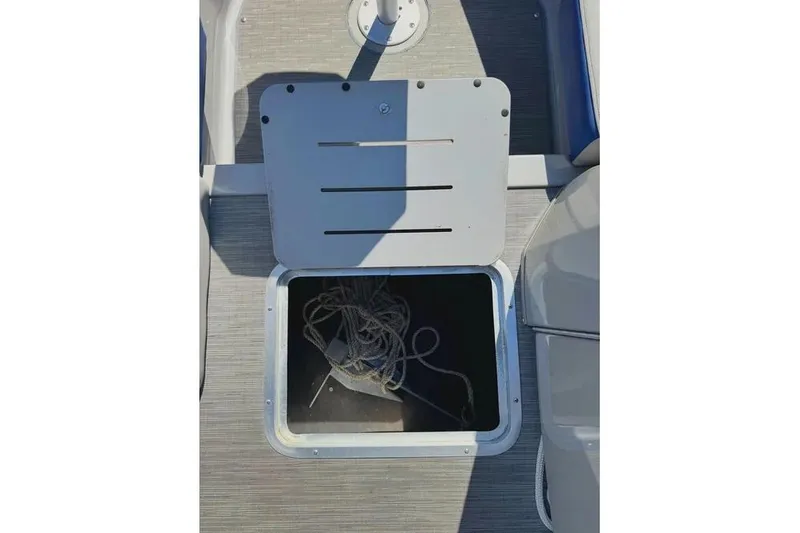 Slide: The Image of Open storage compartment on 2022 Bennington 23 LTFB boat with rope inside. - 12
