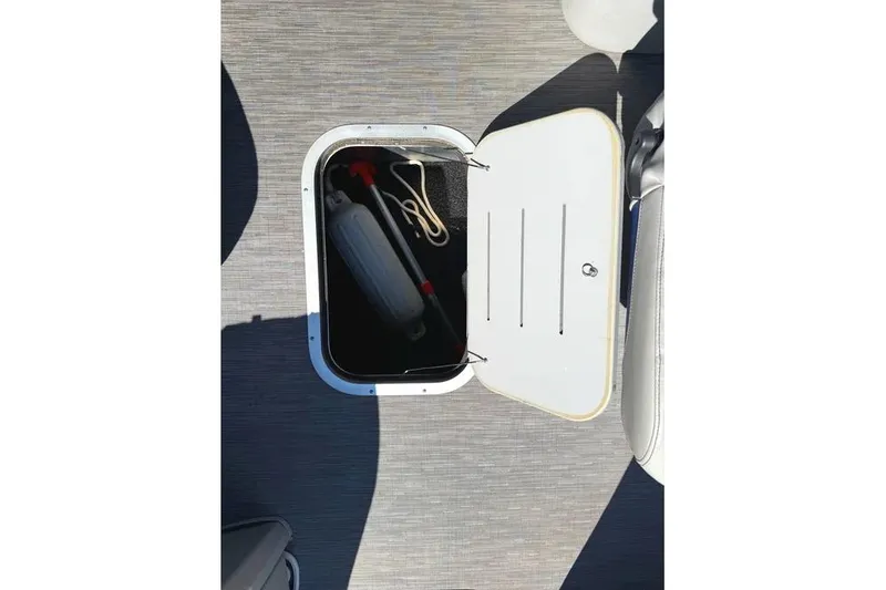 Slide: The Image of Open storage compartment on 2022 Bennington 23 LTFB boat with safety equipment inside. - 13