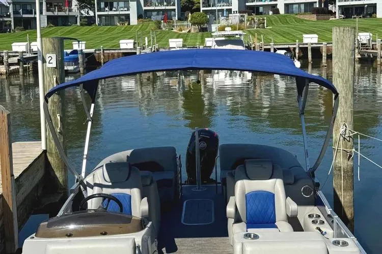 Slide: The Image of 2022 Bennington 23 LTFB pontoon boat docked with blue canopy and seating. - 27