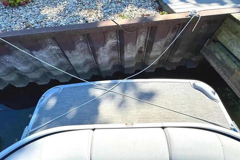 Slide: The Image of 2022 Bennington 23 LTFB boat docked with crossed ropes, top view. - 32