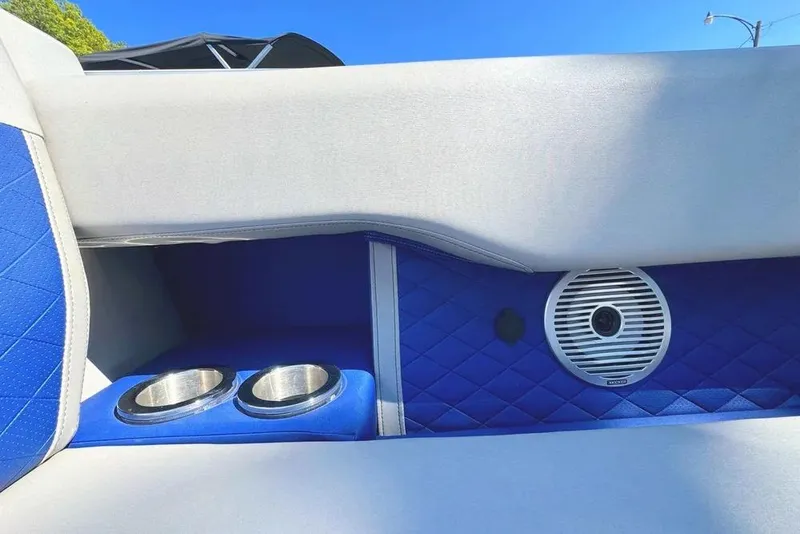 Slide: The Image of 2022 Bennington 23 LTFB boat interior with blue quilted upholstery, cup holders, and speaker. - 8
