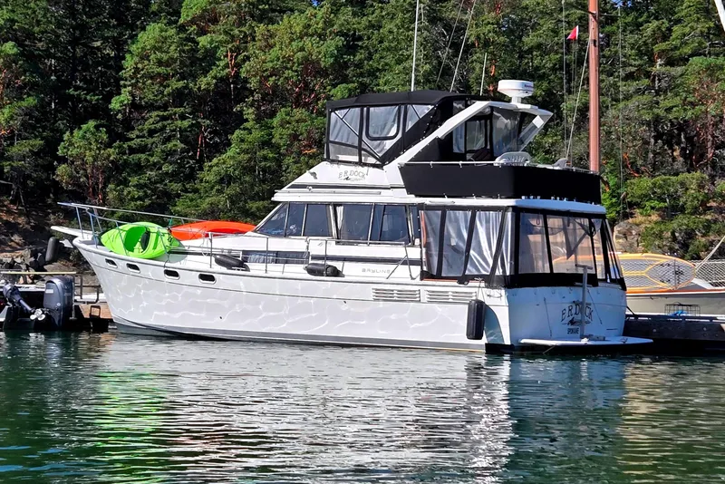 The Image of 1990 Bayliner 3888 Motoryacht docked in a scenic marina setting. - 0