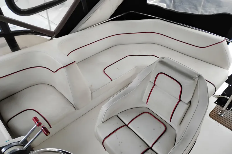 Slide: The Image of 1990 Bayliner 3888 Motoryacht interior with white seating and red trim accents. - 12