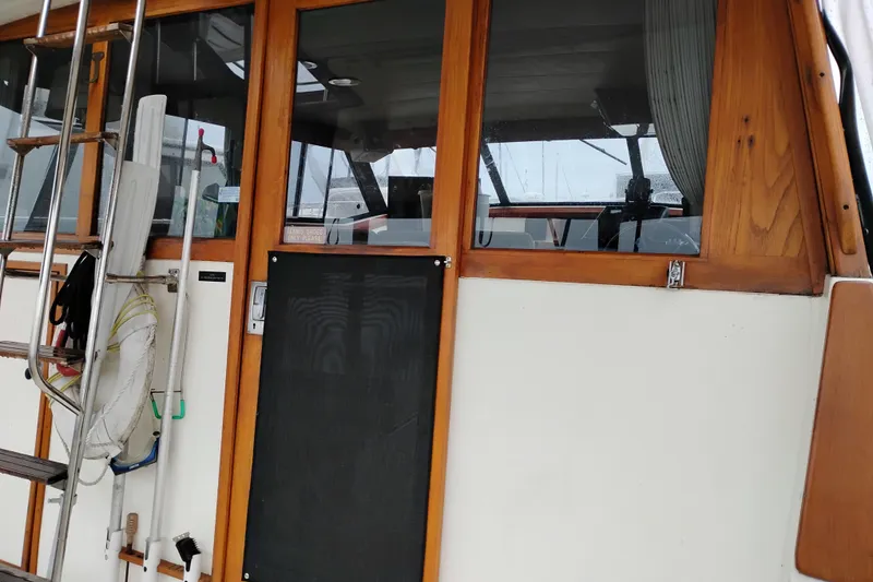 Slide: The Image of 1990 Bayliner 3888 Motoryacht with wooden trim and ladder, docked at marina. - 14