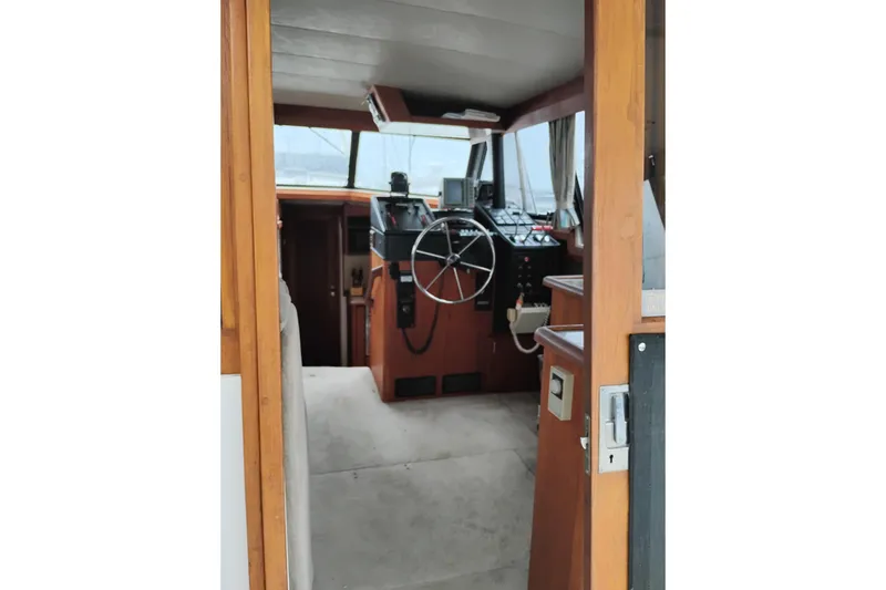 Slide: The Image of 1990 Bayliner 3888 Motoryacht helm with steering wheel and navigation controls. - 15