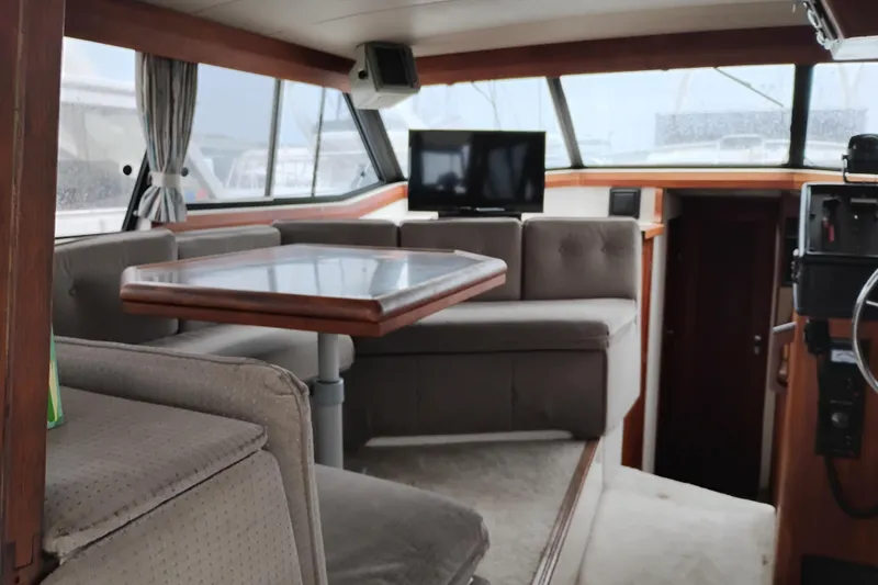 Slide: The Image of Interior of 1990 Bayliner 3888 Motoryacht with seating, table, and TV. - 17