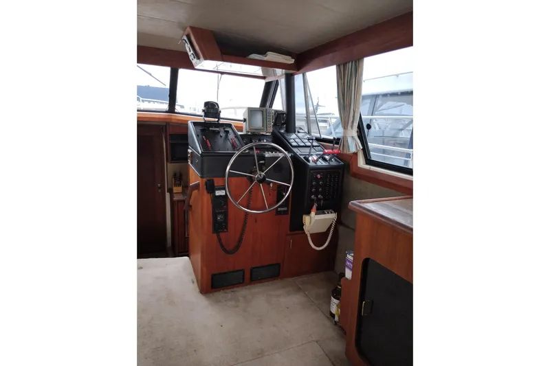 Slide: The Image of 1990 Bayliner 3888 Motoryacht helm with steering wheel and navigation equipment. - 22