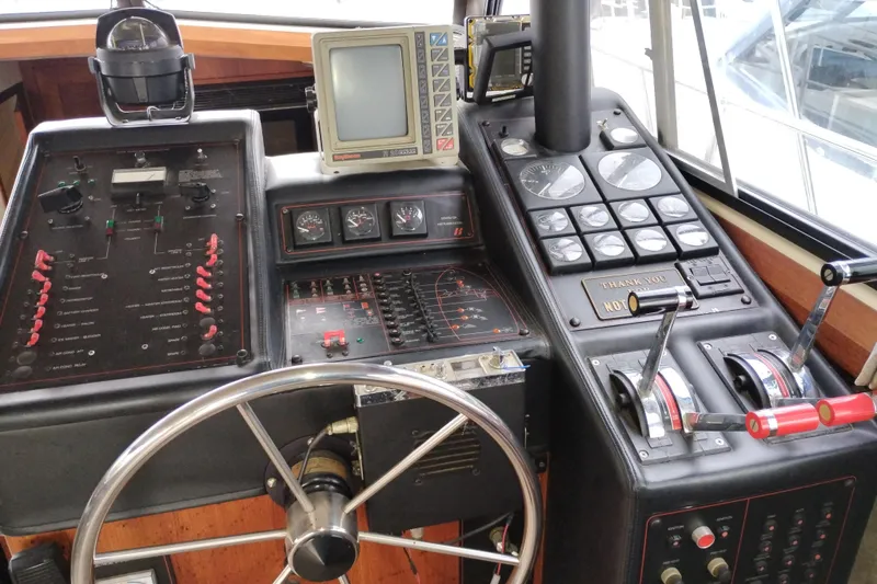 Slide: The Image of Control panel of a 1990 Bayliner 3888 Motoryacht with steering wheel and navigation instruments. - 24