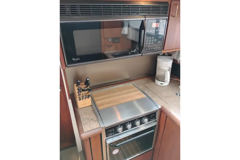 Slide: The Image of 1990 Bayliner 3888 Motoryacht kitchen with stove, microwave, and coffee maker. - 28