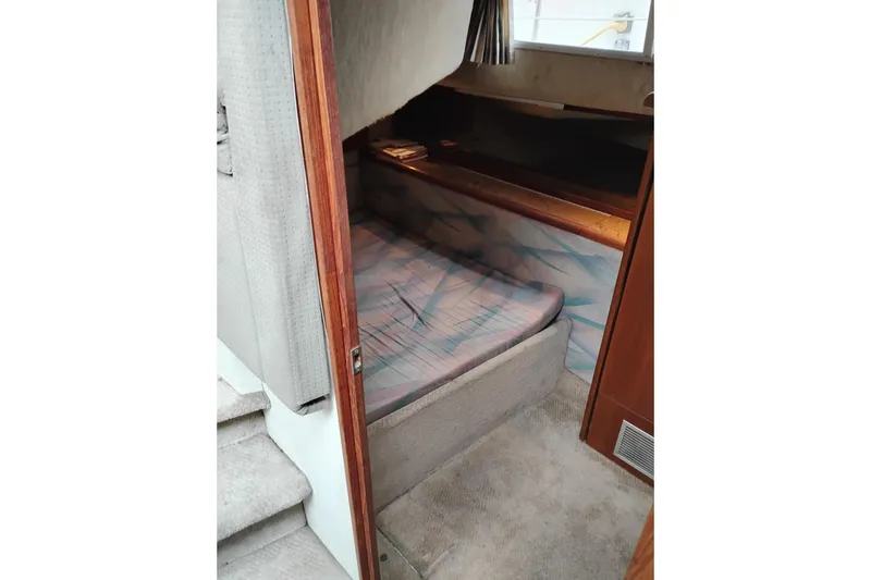 Slide: The Image of 1990 Bayliner 3888 Motoryacht interior cabin with bed and wooden accents. - 33