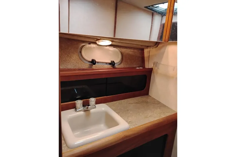 Slide: The Image of 1990 Bayliner 3888 Motoryacht bathroom with sink, mirror, and porthole window. - 43
