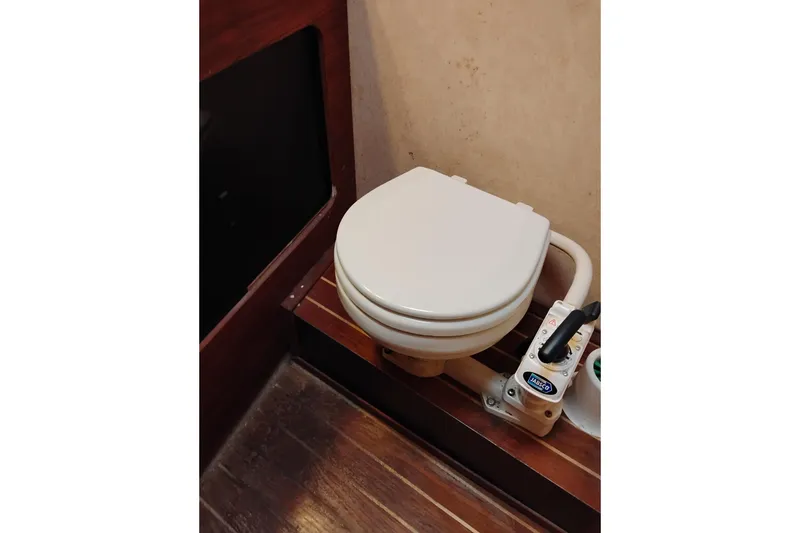 Slide: The Image of 1990 Bayliner 3888 Motoryacht bathroom with marine toilet and wooden flooring. - 44