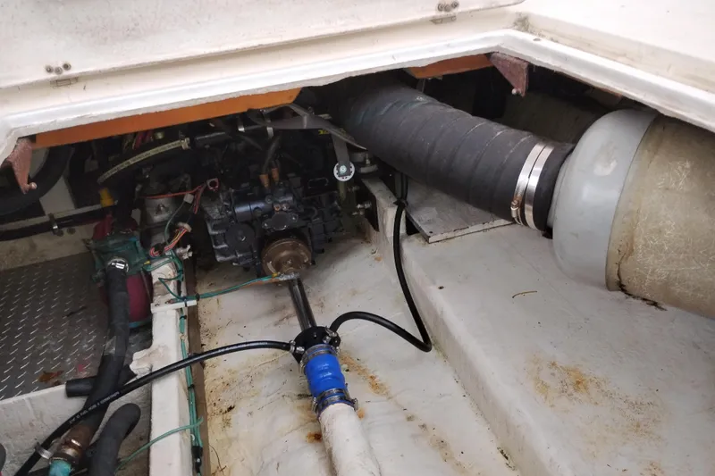 Slide: The Image of Engine compartment of a 1990 Bayliner 3888 Motoryacht, showing mechanical components and hoses. - 51