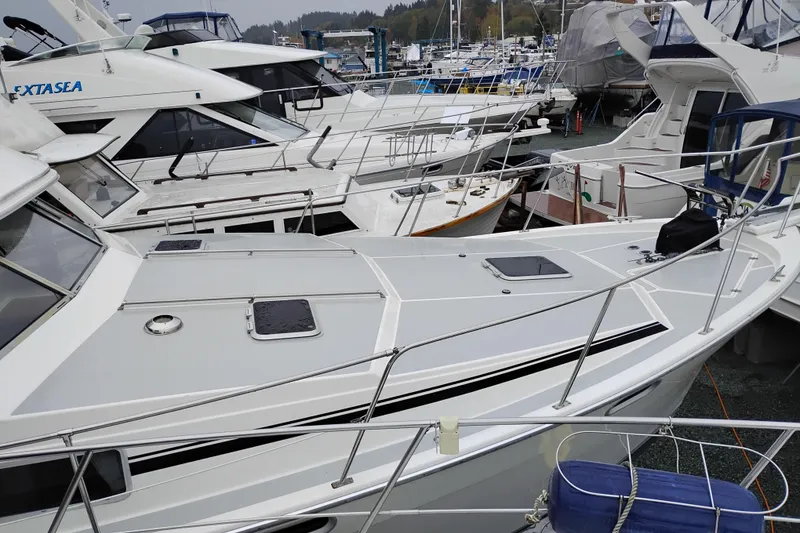 Slide: The Image of 1990 Bayliner 3888 Motoryacht docked among other boats in a marina. - 53