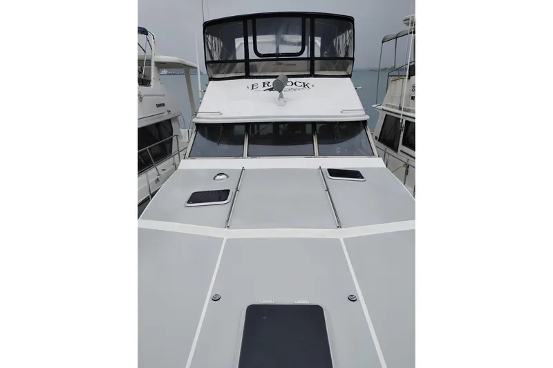 Slide: The Image of 1990 Bayliner 3888 Motoryacht docked, showcasing sleek design and spacious deck. - 54