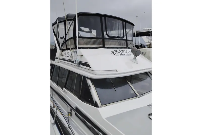 Slide: The Image of 1990 Bayliner 3888 Motoryacht with enclosed flybridge, docked on a cloudy day. - 55