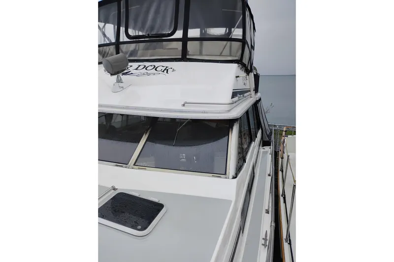 Slide: The Image of 1990 Bayliner 3888 Motoryacht docked, featuring upper deck and windows. - 56