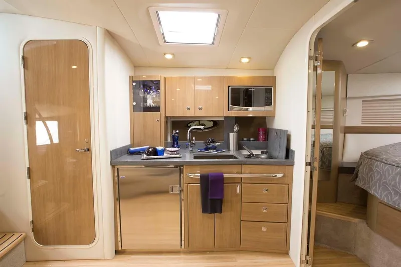 Slide: The Image of 2019 Formula 37 Performance Cruiser interior kitchen with modern amenities and wooden cabinetry. - 29