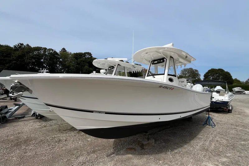 Slide: The Image of 2023 Regulator 28 boat on display, white hull, parked on gravel lot. - 0