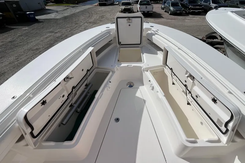 Slide: The Image of 2023 Regulator 28 boat with open storage compartments, showcasing spacious deck design. - 11