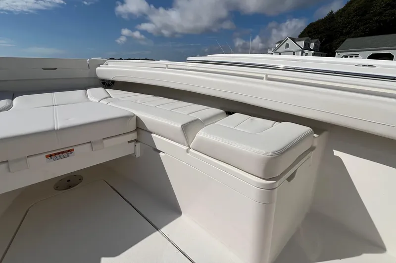 Slide: The Image of 2023 Regulator 28 boat with white cushioned seating under a blue sky. - 14