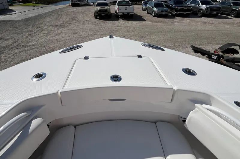 Slide: The Image of 2023 Regulator 28 boat bow with seating and storage, parked in a lot. - 16