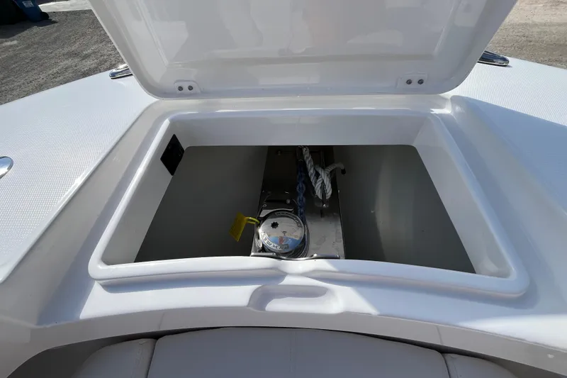 Slide: The Image of Open storage compartment on 2023 Regulator 28 boat, featuring anchor and rope. - 17