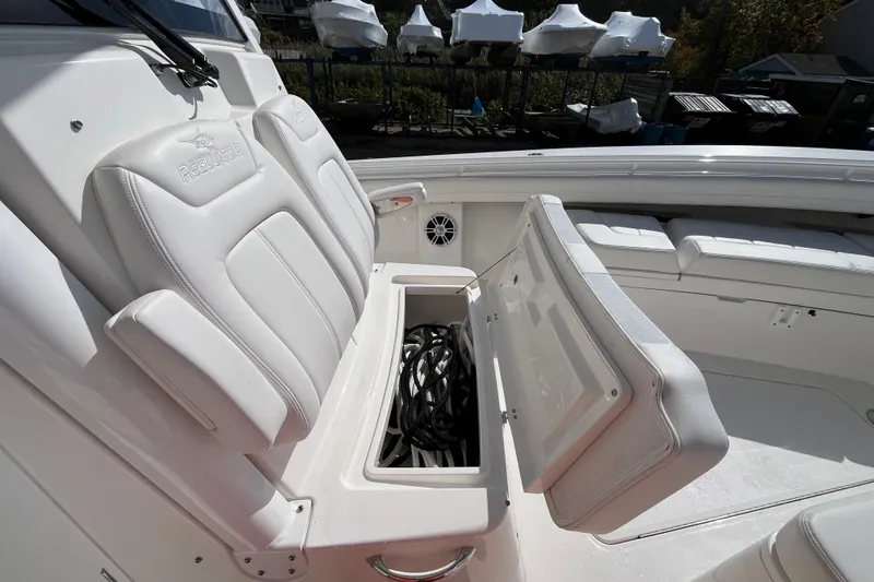 Slide: The Image of 2023 Regulator 28 boat interior with open storage compartment and white seating. - 24
