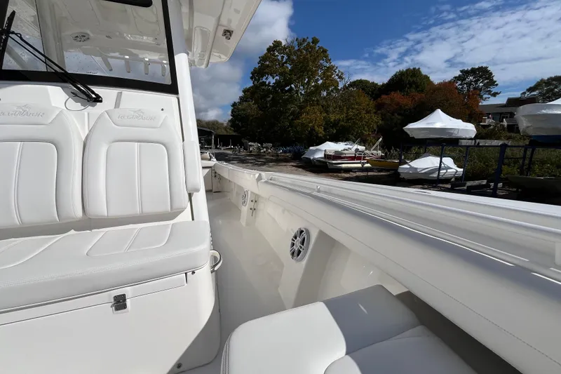 Slide: The Image of 2023 Regulator 28 boat interior with white seating, docked near covered boats. - 26