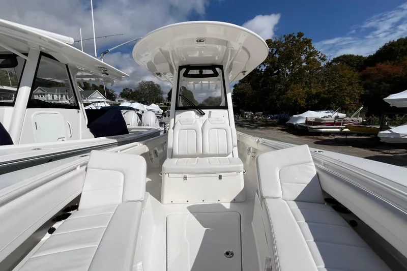Slide: The Image of 2023 Regulator 28 boat with white seating and console, docked outdoors under blue sky. - 27
