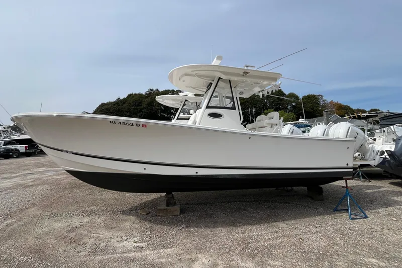 Slide: The Image of 2023 Regulator 28 boat on display, white hull, parked on gravel lot. - 3