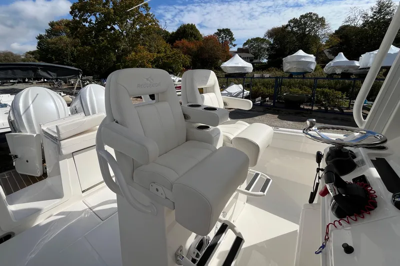 Slide: The Image of 2023 Regulator 28 boat interior with white captain's chairs and steering wheel. - 30