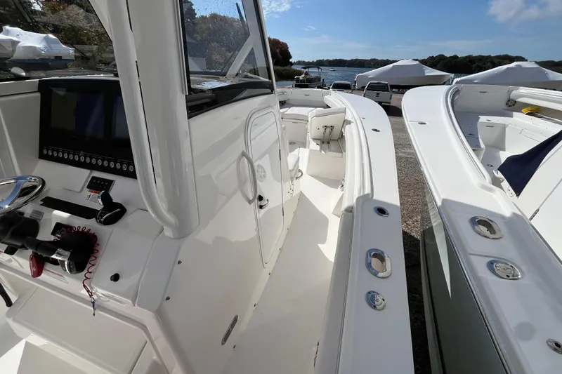 Slide: The Image of 2023 Regulator 28 boat interior with helm, seating, and controls, docked near water. - 31