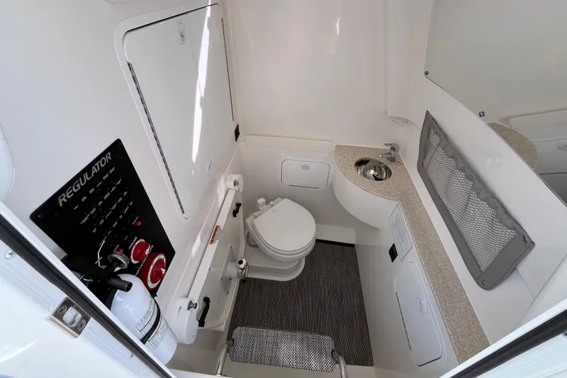 Slide: The Image of 2023 Regulator 28 boat interior with toilet, sink, and control panel. - 32