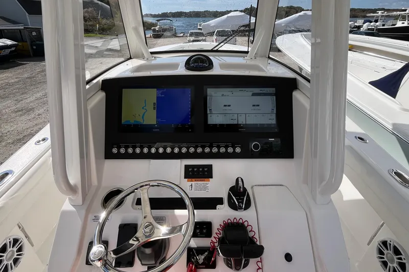 Slide: The Image of 2023 Regulator 28 boat dashboard with dual screens and steering wheel. - 35