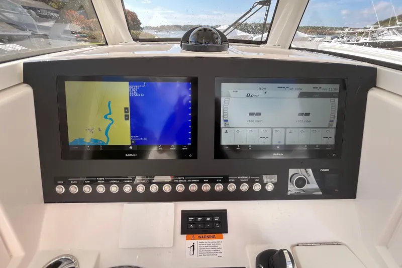 Slide: The Image of 2023 Regulator 28 boat dashboard with dual Garmin displays and control panel. - 36