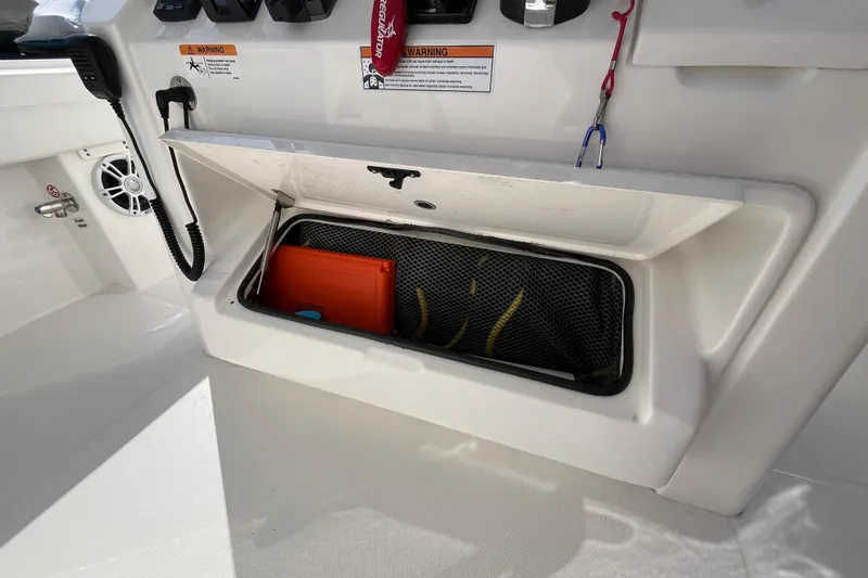 Slide: The Image of 2023 Regulator 28 boat storage compartment with safety equipment and accessories. - 38