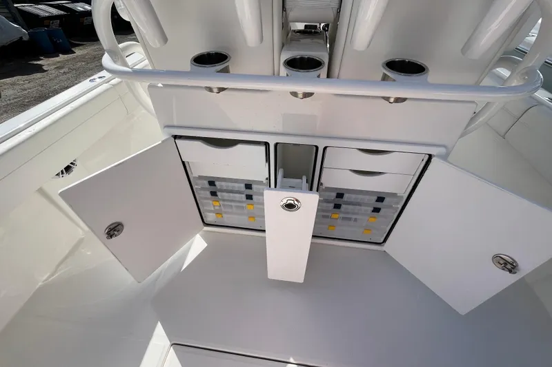 Slide: The Image of 2023 Regulator 28 boat storage compartments with open doors and organized tackle boxes. - 41
