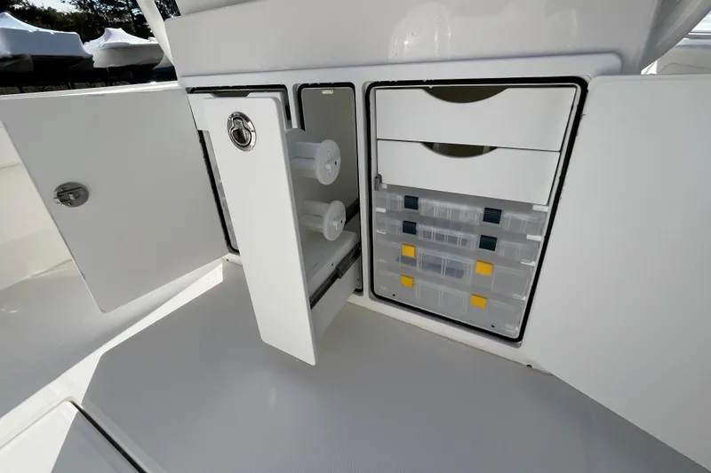 Slide: The Image of 2023 Regulator 28 boat storage compartments with organized tackle boxes and drawers. - 42