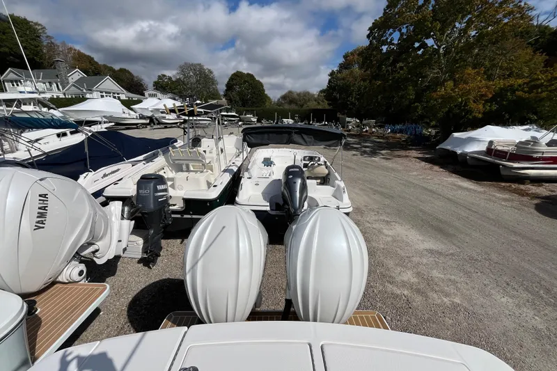 Slide: The Image of 2023 Regulator 28 boat with Yamaha engines in a marina, surrounded by other boats. - 49